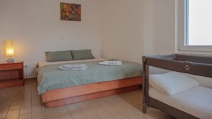 A bedroom with a bed, a bedside table with a lamp, a window, and a painting on the wall. - Perfect apartment for 3 with terrace/wifi/pet-friendly (Fazana)