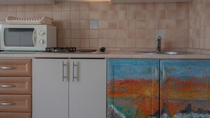 A kitchen with a microwave, stove, and cabinets. - Perfect apartment for 3 with terrace/wifi/pet-friendly (Fazana)
