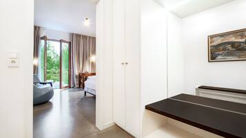 A modern hotel room with a large bed, a desk, and a view of the outdoors.