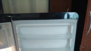 A refrigerator with multiple shelves containing bottles.