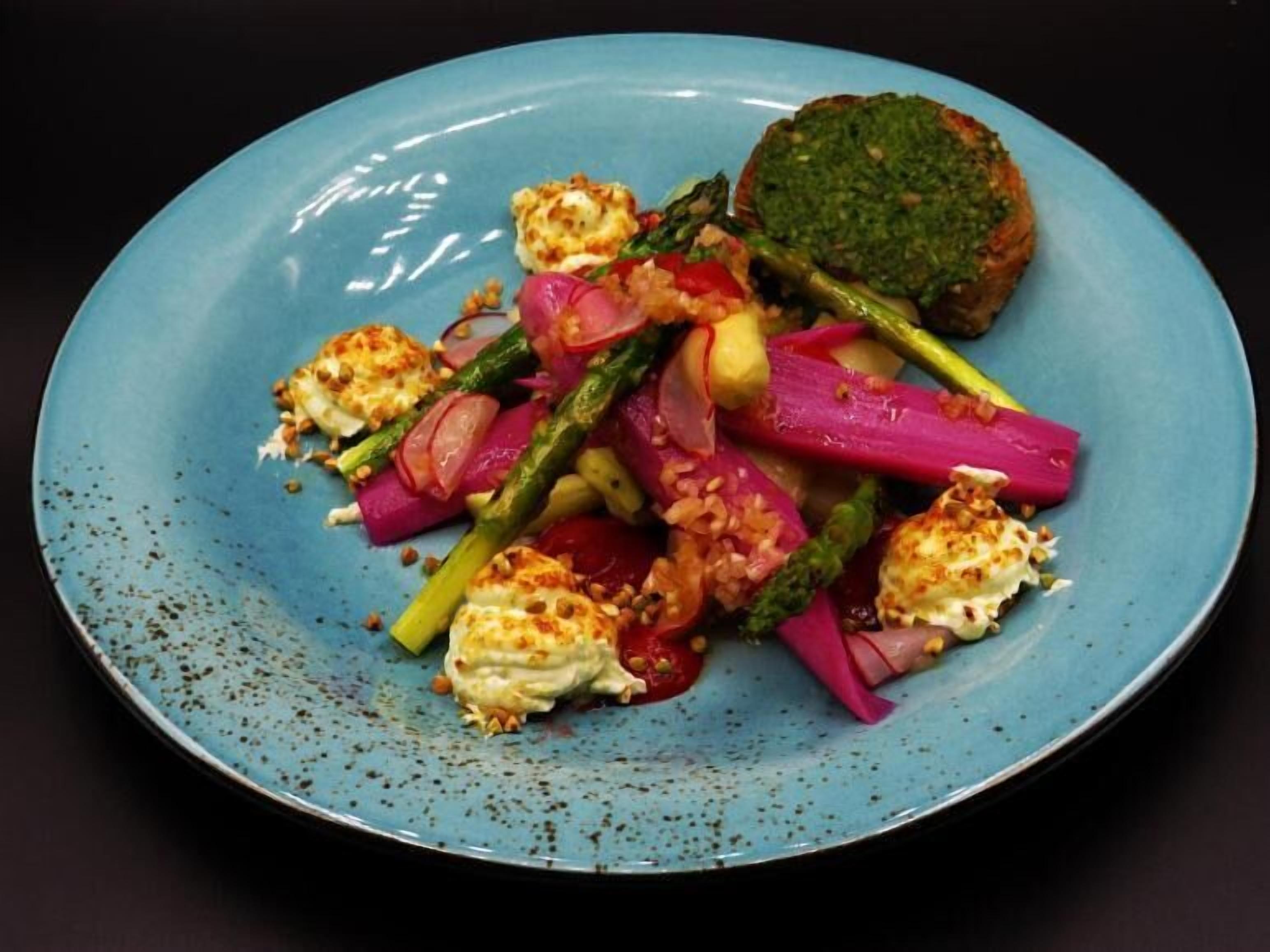 Un plato con una variedad de verduras y una rebanada de pan.