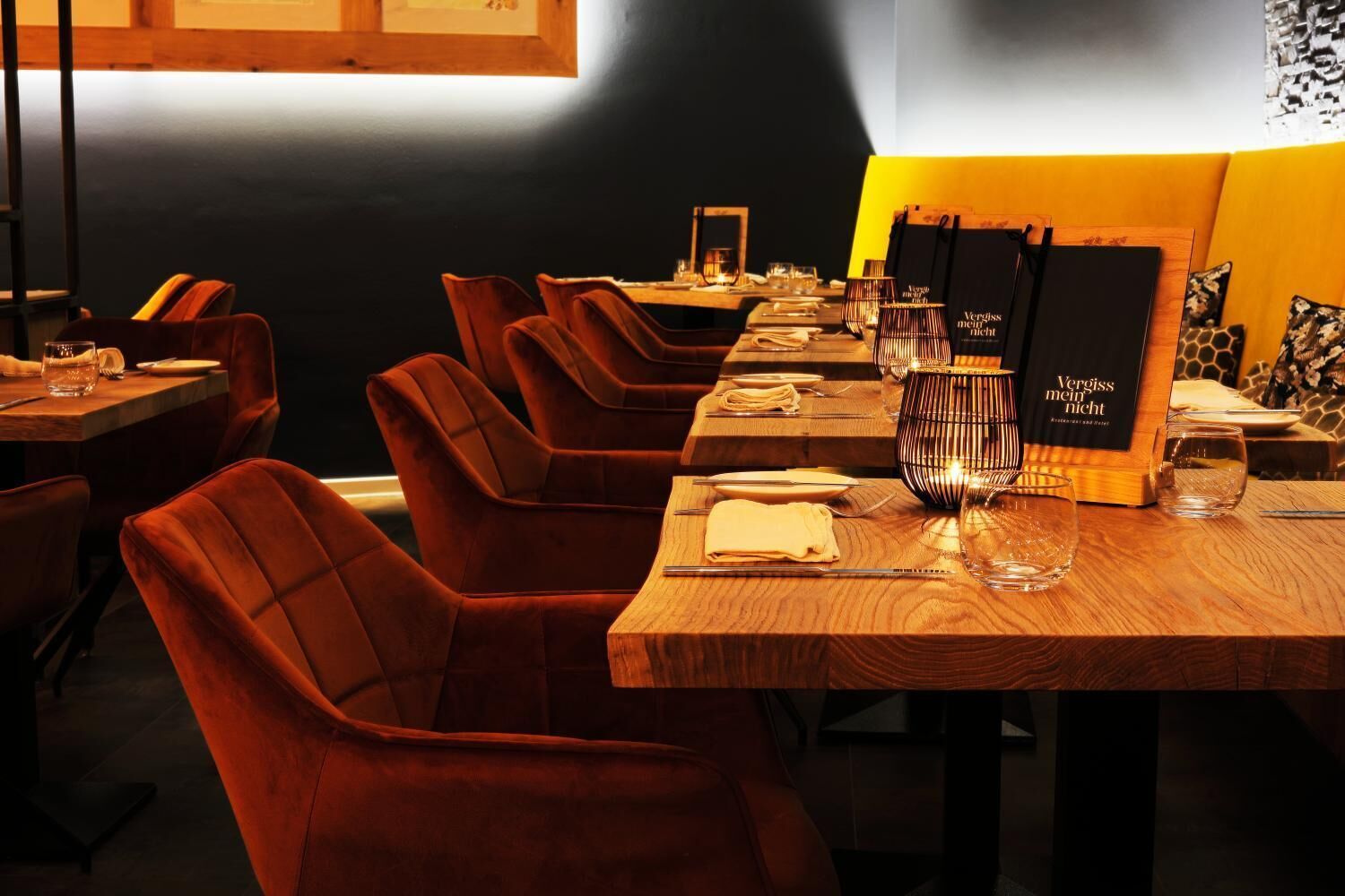 Un restaurante con mesas de madera y sillas tapizadas rojas.