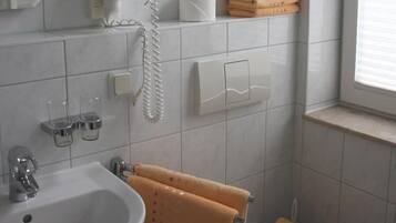 A bathroom with a sink, toilet, and a towel rack with towels.