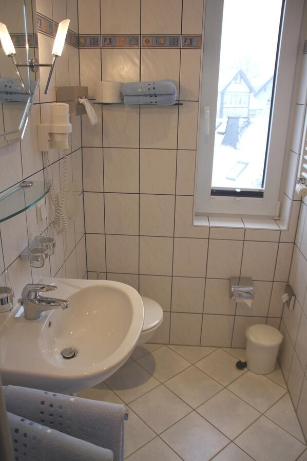 A bathroom with a sink, mirror, towel rack, and a window. - Haus Vergißmeinnicht (Oberhof)