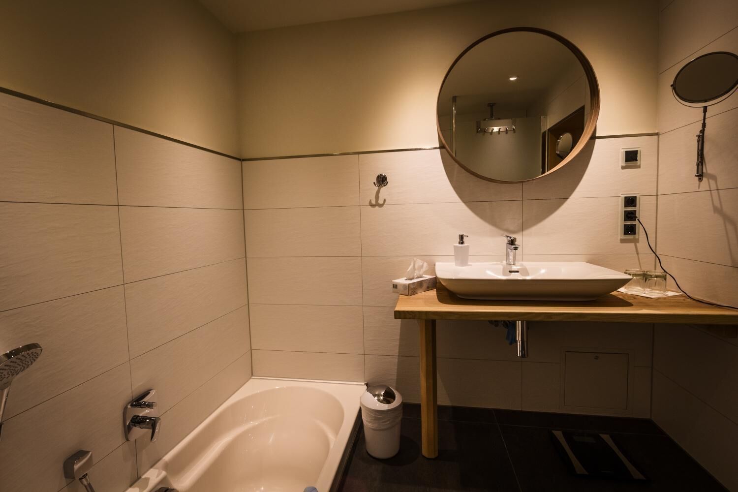 Un baño moderno con bañera, lavamanos con espejo y ducha.