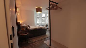 Ein Schlafzimmer mit Bett, Nachttisch, Lampe und einer Pendelleuchte.