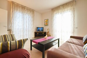 Departamento básico, 2 habitaciones | Sala de estar | Televisión de pantalla plana 