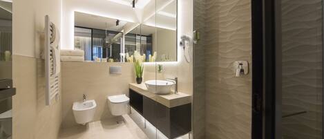 A modern bathroom with a bidet, a sink, and a large mirror.