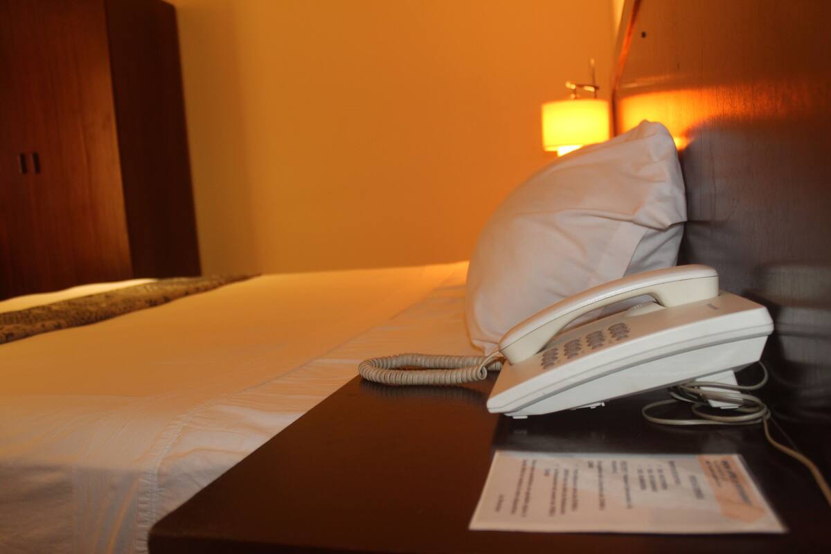 Escritorio, cortinas blackout y tabla de planchar con plancha
