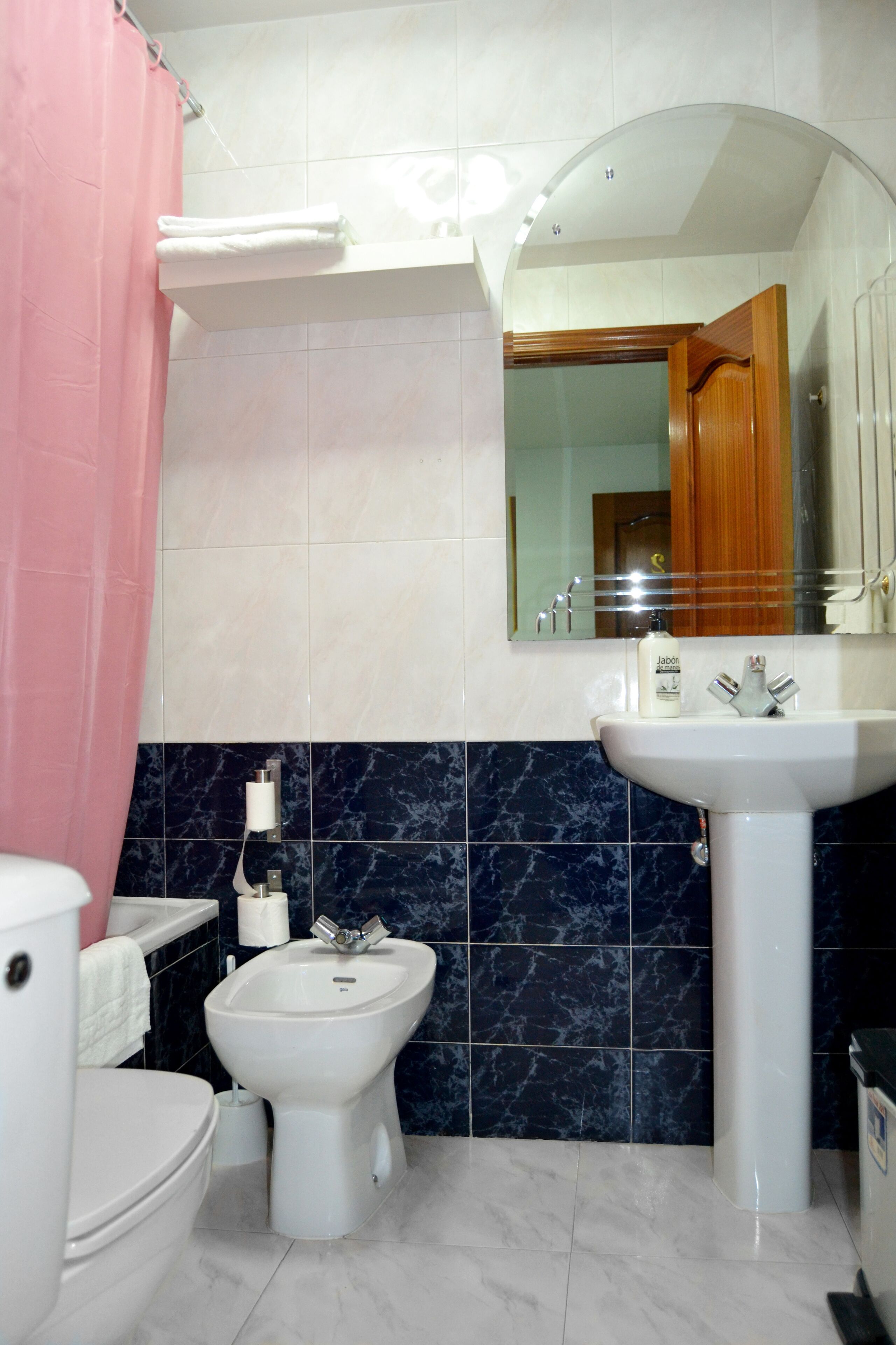 Un baño con inodoro, lavabo, espejo y bidé.