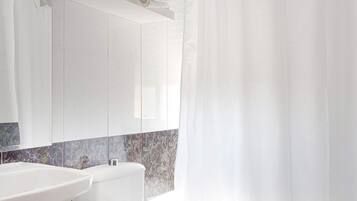 Un baño moderno con inodoro, lavamanos y bañera.