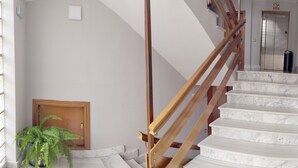 A staircase with wooden handrails and marble steps leading to an elevator. - Hostal Lady Ana Maria (Collado Villalba)