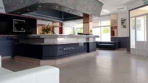 A hotel reception area with a modern design, including a counter labeled 'HOSTAL LADYANA' and a seating area with a couch. - Hostal Lady Ana Maria (Collado Villalba)