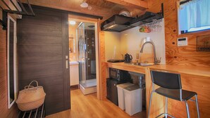 Una cocina compacta con un lavamanos, una cafetera y un refrigerador.