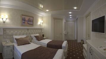 A hotel room with two beds, a painting on the wall, a television, and a small desk with a phone.