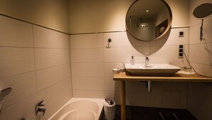 Une salle de bain moderne avec une baignoire, un lavabo et un miroir.