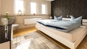 Une chambre moderne avec un grand lit, un radiateur et une fenêtre donnant sur un beau paysage.