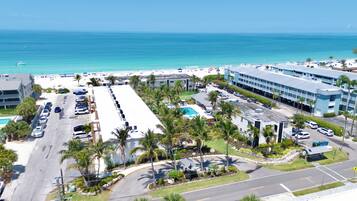 Ein Hotel mit Pool, Parkplatz und Blick auf Strand und Meer.