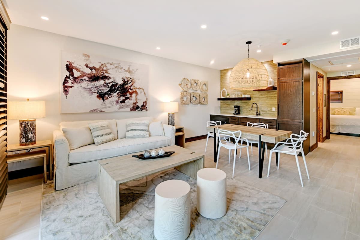 A modern living room with a sofa, coffee table, and dining area.