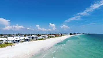 A coastal resort with beachfront properties, clear skies, and turquoise waters.