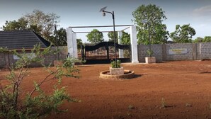 A fenced outdoor area with a gate, a solar streetlight, and a signboard.