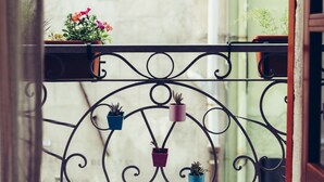 A balcony with wrought iron railings and potted plants. - B&B Blu Bosa (Bosa)