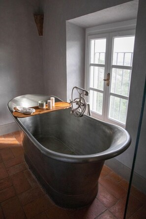 A vintage clawfoot bathtub with a wooden shelf, a towel, and toiletries. - Luxury 6-bed Tuscan Villa Near Lucca and Florence (Capannori)