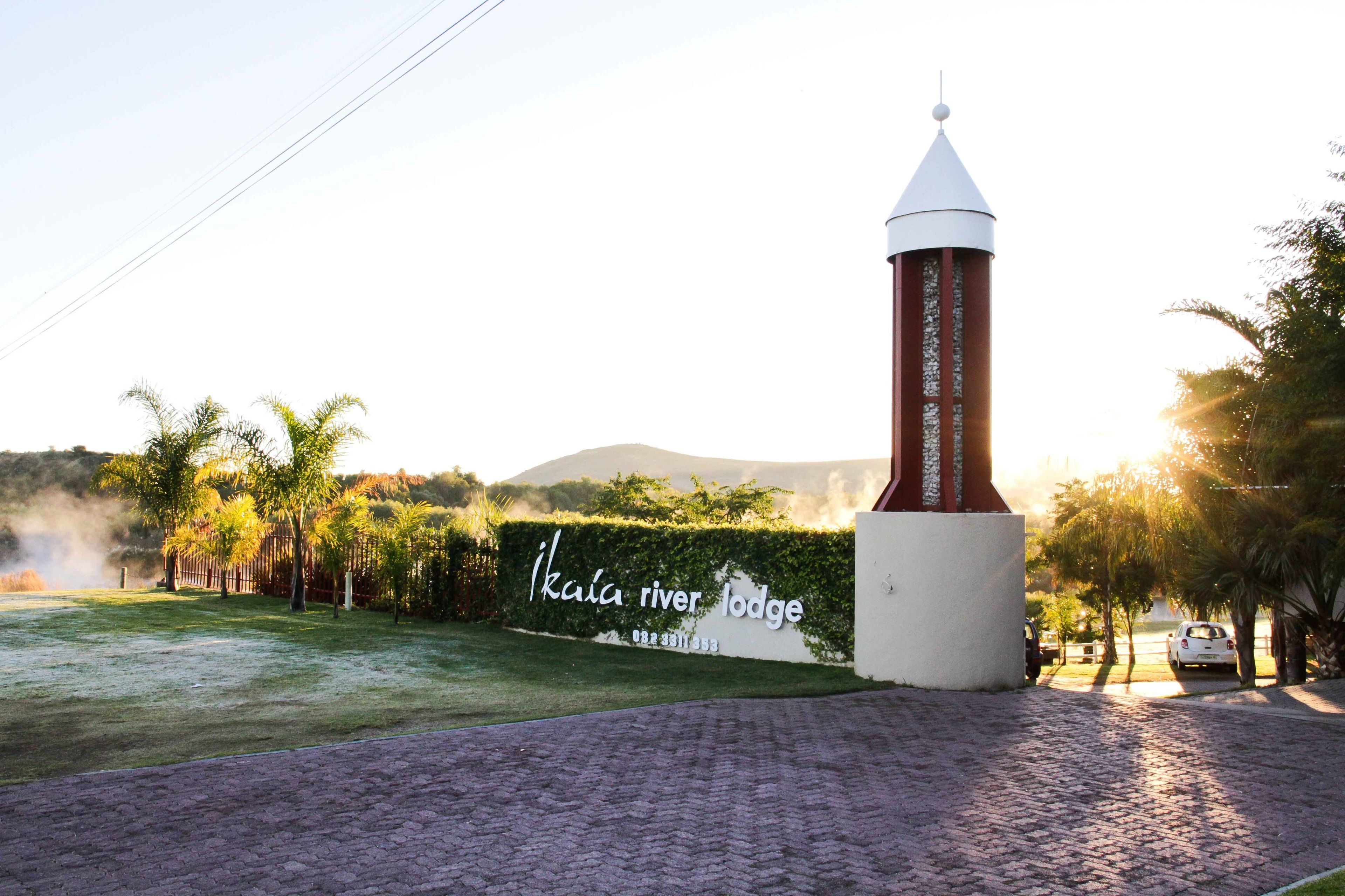 A lodge entrance with a sign reading "Ikala River Lodge" and a brick pathway leading to the building.
