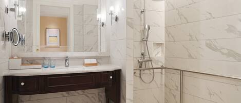 A modern bathroom with a marble vanity, a large mirror, and a walk-in shower with a glass door.
