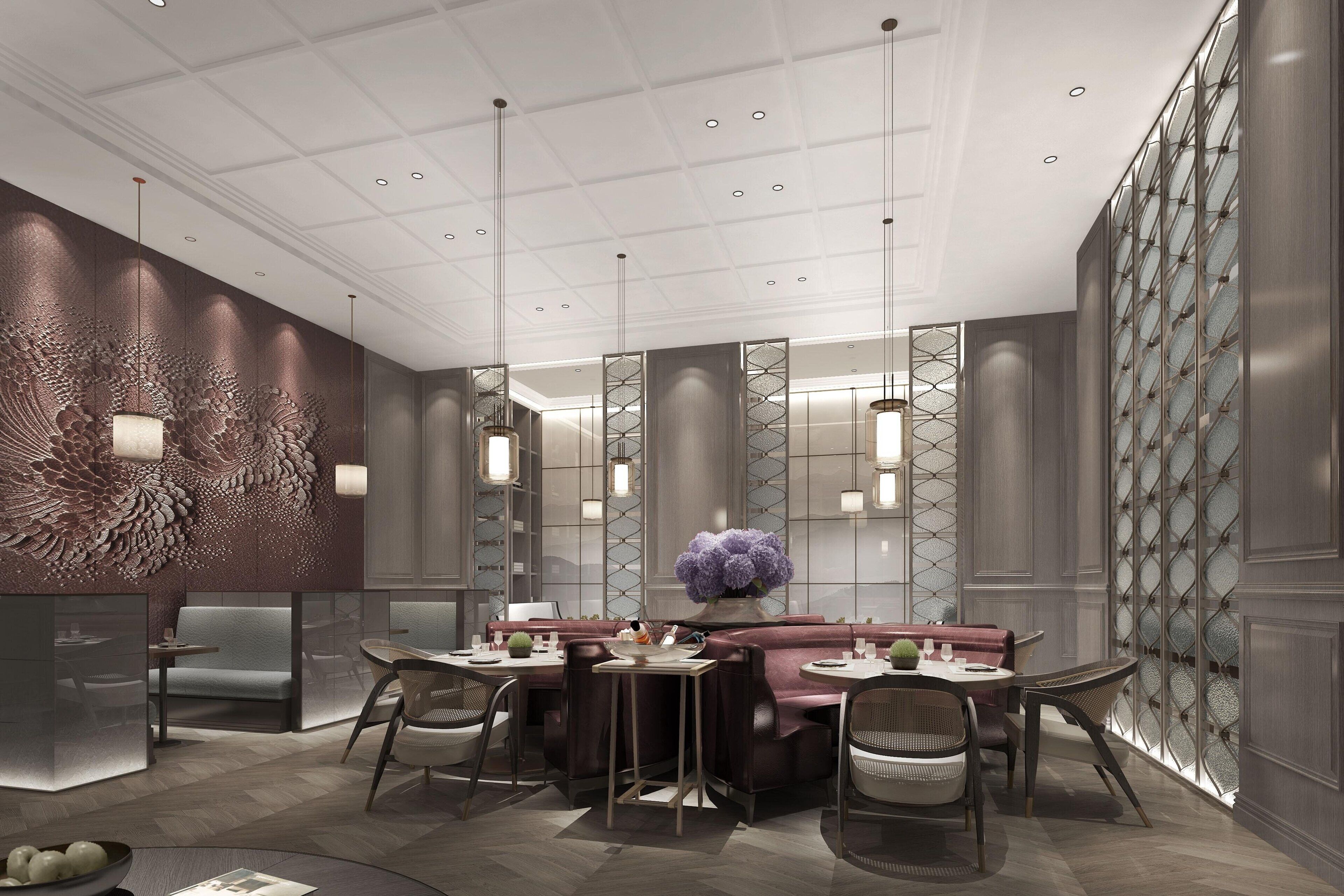 A modern interior with a central seating area, high ceiling with recessed lighting, and decorative wall panels.