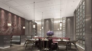 A modern interior with a central seating area, high ceiling with recessed lighting, and decorative wall panels.