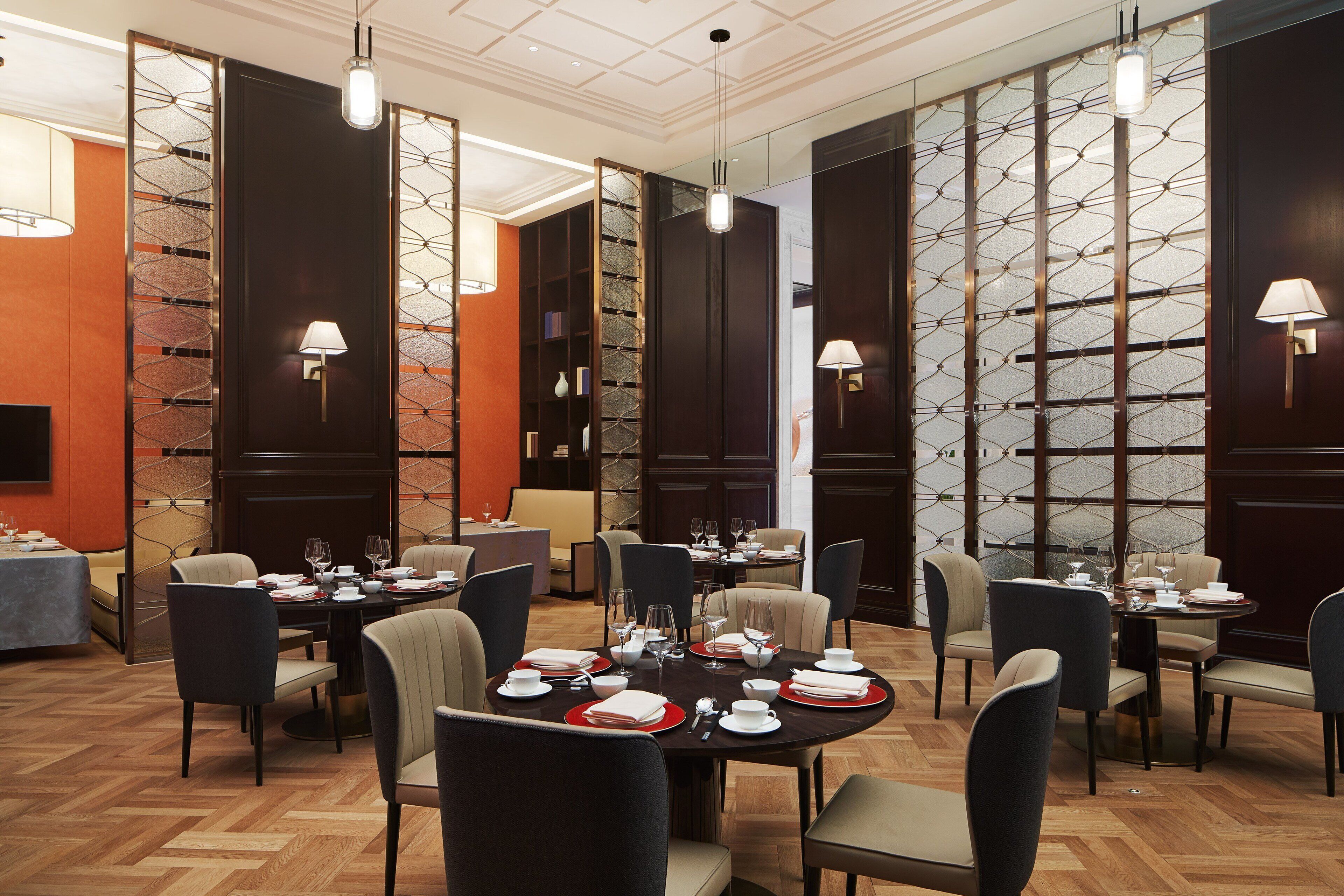 Un espace repas avec des tables rondes dressées pour le repas, entourées de chaises.