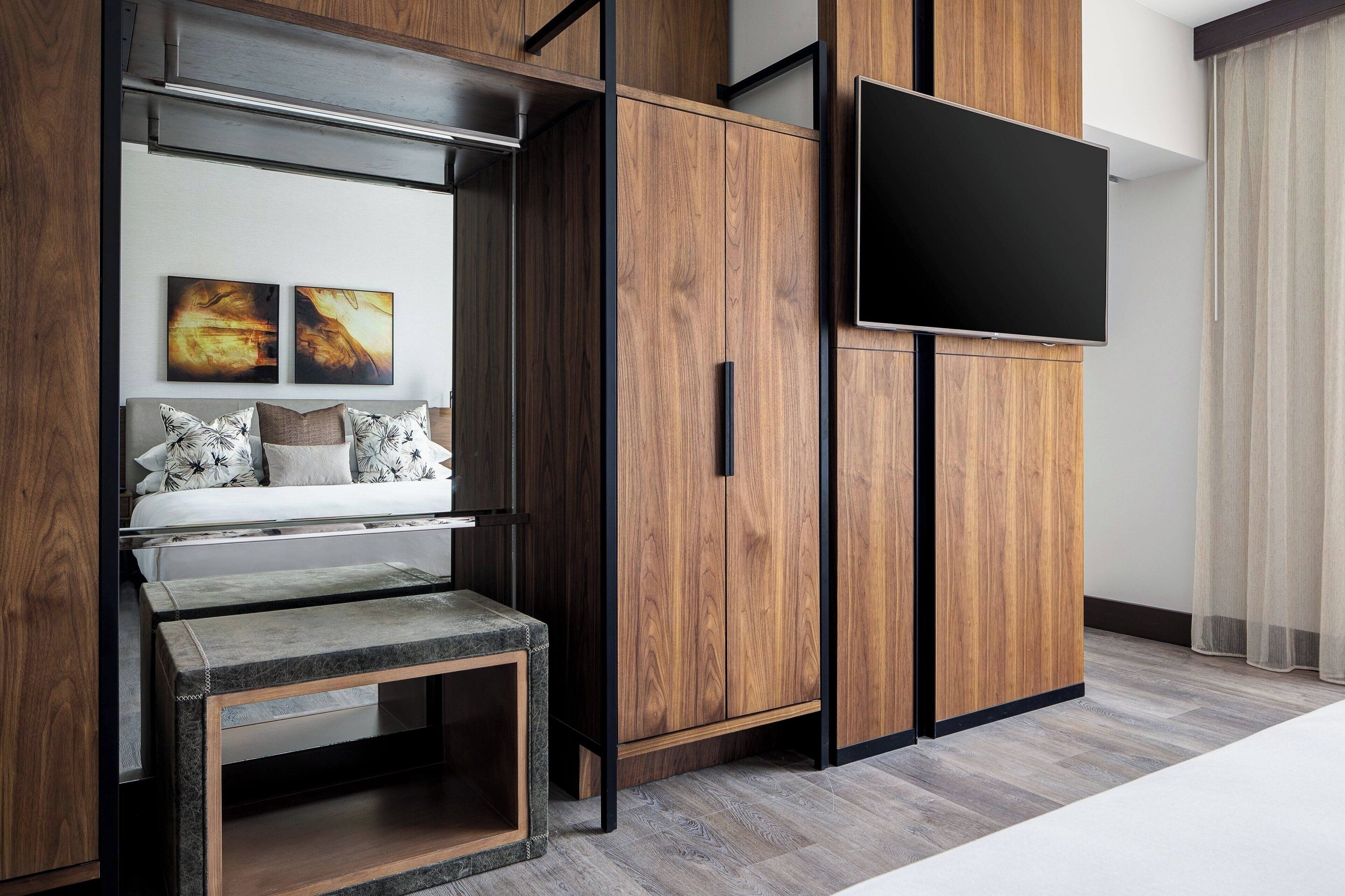 Una sala de estar moderna con un sofá, una mesa de centro y un televisor montado en un mueble de madera.