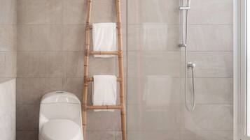 Baño con inodoro, escalera de bambú y ducha.
