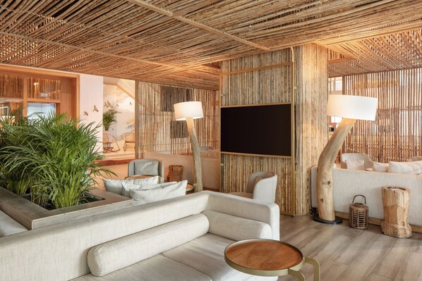 A modern living room with a sofa, a coffee table, and a TV. - Santa Marta Marriott Resort Playa Dormida (Santa Marta)