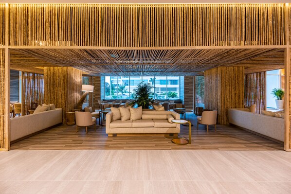A modern lounge area with a sofa, chairs, and a round table.