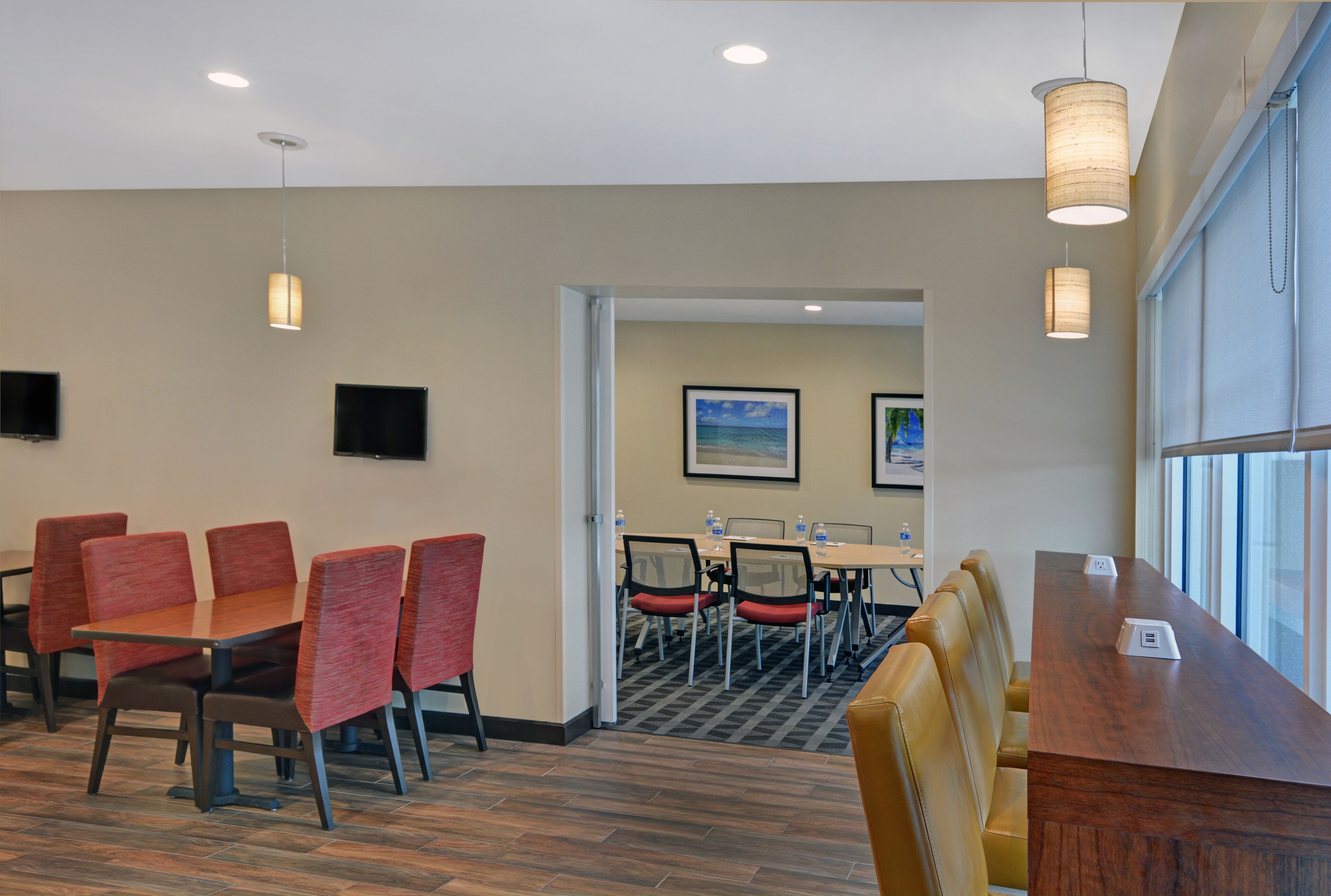 A conference room with a long table, multiple chairs, and pendant lighting.