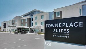 Towneplace Suites by Marriott con un edificio moderno, un estacionamiento y un cielo despejado.
