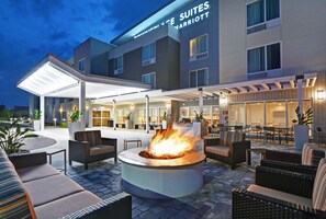 A hotel exterior with a covered outdoor seating area, a fire pit, and a sign for "Townhouse Suites Marriott". - TownePlace Suites by Marriott Sarasota Bradenton West (Bradenton)