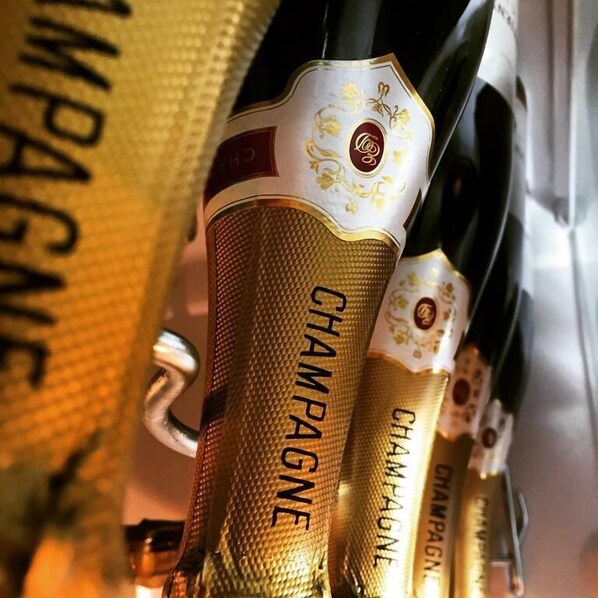 A close-up of a bottle with the label "CHAMPAGNE" and a gold textured grip. - Westcroft Guesthouse (Torpoint)