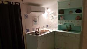Une cuisine équipée d’un évier, de placards et d’une étagère décorative.