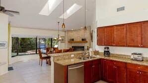A modern kitchen with granite countertops, wooden cabinets, and a built-in dishwasher. - Ellen`s House-pool and Jacuzzi, Gulf access (Cape Coral)