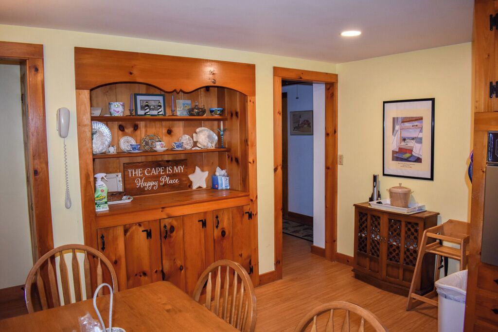 Un coin repas avec des meubles de rangement en bois, une table et des chaises.