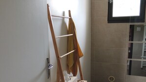 A bathroom with a wooden towel rack, a window, and a bathtub. - Les Chataigniers (Saint-Sebastien-d'Aigrefeuille)