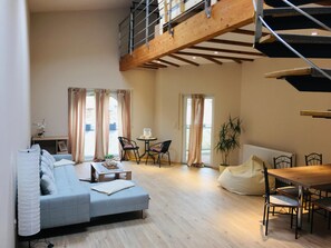 A spacious living area with a loft bedroom, a dining table, and a sofa. - Vacation apartment at the Nürburgring/ winter sports Arft,, offer at the beginning of the year,, (Acht)