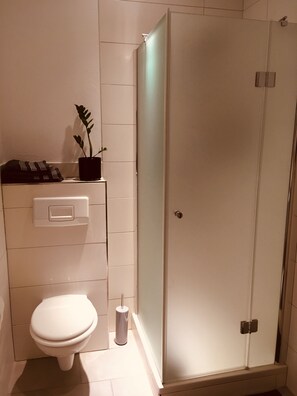 Een douche, handdoeken, zeep, shampoo