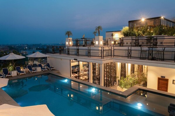 A rooftop swimming pool with lounge chairs and a dining area. - Hari Residence & Spa (Siem Reap)