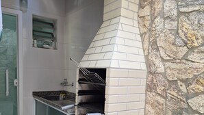A kitchen with a stone wall, a built-in oven, and a sink.