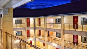 A multi-level hotel interior with a central atrium, glass railings, and a ceiling mural. - Regent Palace Hotel (Freetown)