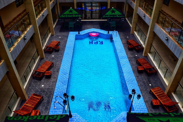 Una piscina al aire libre, sombrillas, tumbonas